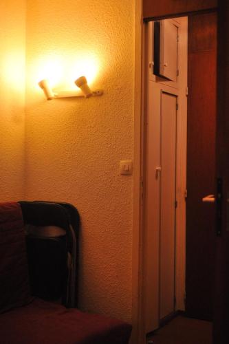 a room with a light on the wall and a door at Studio Les Menuires Brelin in Les Menuires