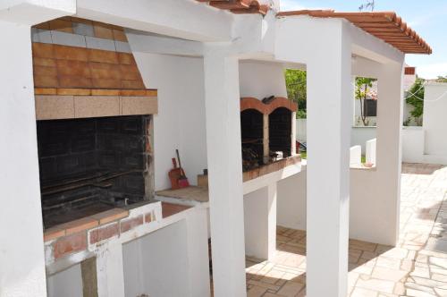 a kitchen area with a stove, oven and a fire place at Apartamentos Campos 0 in Porto Covo