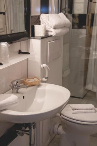 a white bathroom with a sink and a toilet at Hotel Letizia in Orte
