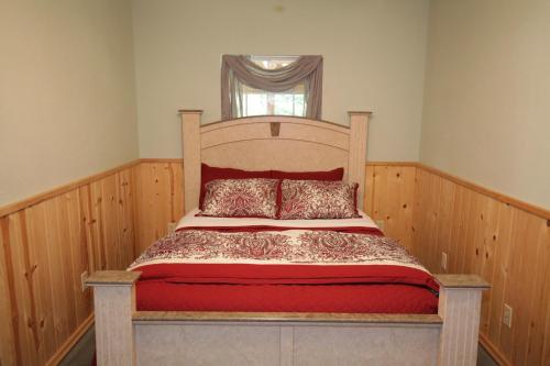 1 cama con marco de madera en una habitación con ventana en Hope's Hideaway, LLC, en Hope