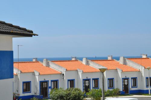 a row of houses with orange roofs at Apartamentos Campos 1 in Porto Covo