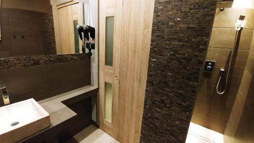 a bathroom with a shower with a sink and a mirror at Villa Garden Kutno Centrum in Kutno
