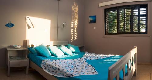 Schlafzimmer mit einem Bett mit blauer Bettwäsche und Kissen in der Unterkunft Annita Court Block B, Apt6 in Ayia Napa