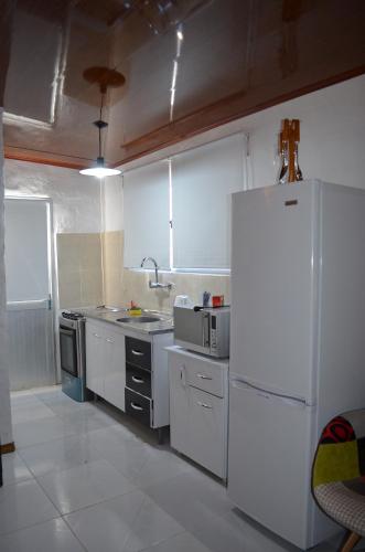 een keuken met witte apparatuur en een witte koelkast bij Casa La Norma in Nueva Palmira