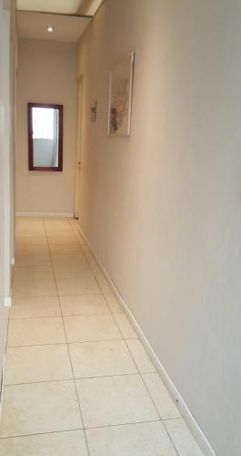 a hallway with white walls and a tile floor at Hotel Praga in Gualeguaychú