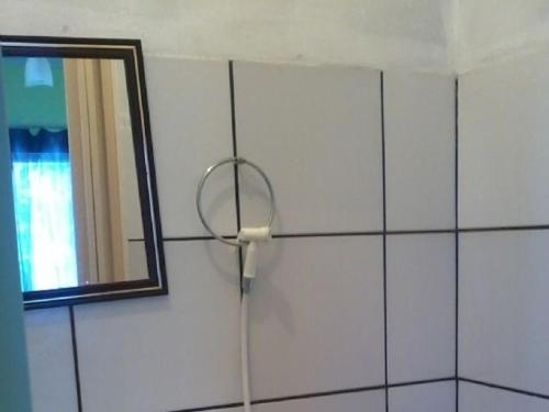 a mirror on a wall next to a shower at Pousada Luar de Monte Cristo in Araripe de Baixo