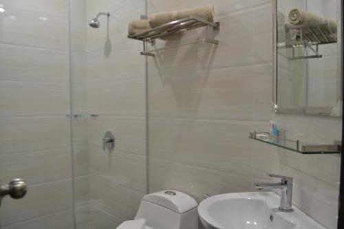 a bathroom with a shower and a toilet and a sink at My Inn Hotel Kota Samarahan in Kota Samarahan