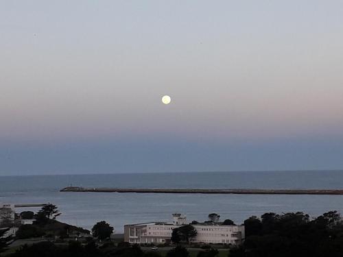 a moon in the sky over the water with buildings at ESPECTACULAR Alem 5007 piso 7 in Mar del Plata