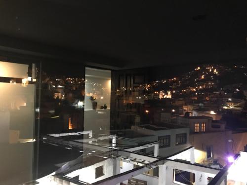a room with a view of a city at night at Carcamanes 17 Gastro-Hotel in Guanajuato