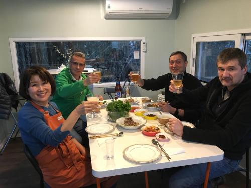 a group of people sitting around a table drinking champagne at Poema Stay Pension in Jeju