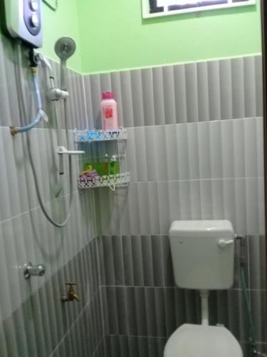 a bathroom with a shower and a toilet in it at Mirza Homestay Marang in Marang