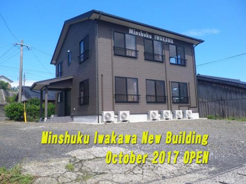 un edificio con una señal delante de él en Minshuku Iwakawa, en Yakushima