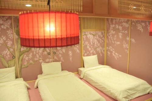 a room with two beds and a red lamp at Stay SAKURA Tokyo Asakusa Townhouse in Tokyo