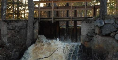 a wooden bridge over a stream of water at STF Kungsgården Långvind in Enånger