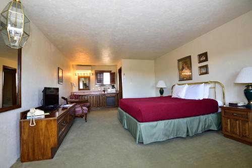 Sequim West Inn في سيكيم: غرفة نوم بسرير كبير مع بطانية حمراء