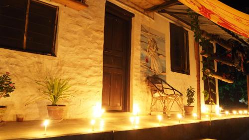 a room with a door and a chair on a mantle with candles at Peace Guest House in Pokhara