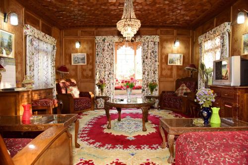 a living room with a chandelier and a table at White House Group Of Houseboats in Srinagar