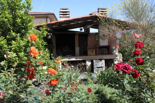 a garden with flowers in front of a house at Holiday Home Villa Bobolino in Montelupo Fiorentino