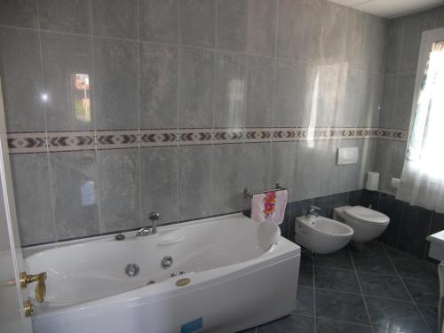 a bathroom with a white tub and a toilet at Holiday Home Villa Bobolino in Montelupo Fiorentino