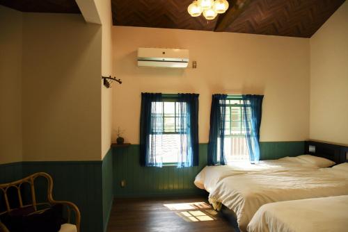 a bedroom with two beds and two windows at CoBo Hostel in Kyoto