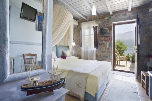 a bedroom with a large bed and a balcony at Elixirion Guest House in Karavostasion
