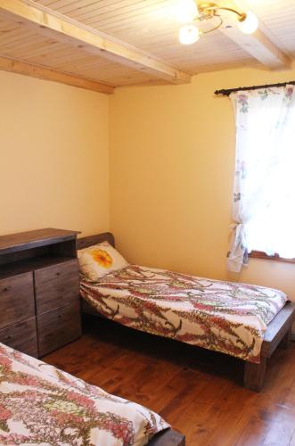 a bedroom with two beds and a dresser and a window at Svit Sontsya in Turʼya Polyana