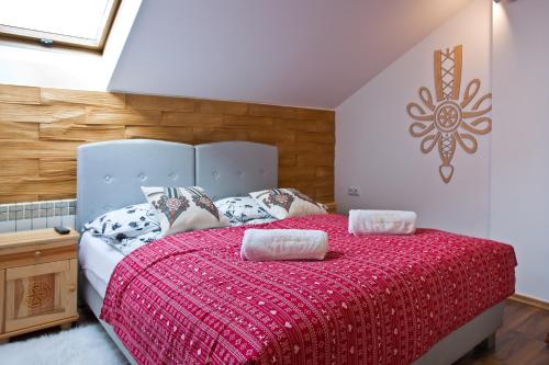 a bedroom with a large bed with a red comforter at Apartament City Center Sky in Krynica Zdrój