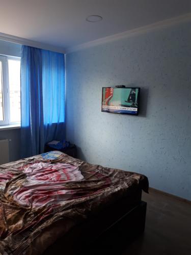 een slaapkamer met een bed en een foto aan de muur bij The ideal penthouse in Tbilisi City