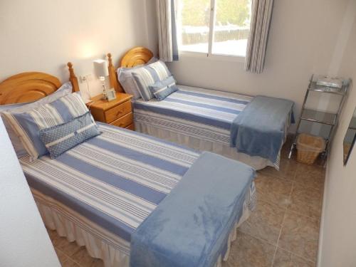 オリフエラ・コスタにあるAppartement Campoamor Beach, Orihuela Costaのベッドルーム1室(ベッド2台、窓付)