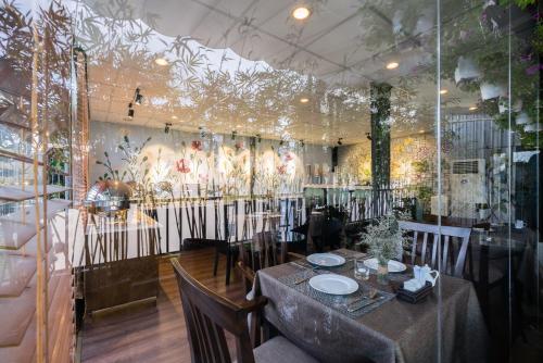 a dining room with a table and chairs and a mural at Asian Ruby Center Point Hotel & Spa in Ho Chi Minh City