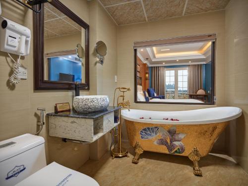 a bathroom with a large mirror and a bath tub at Eden Boutique Hotel & Spa in Sa Pa