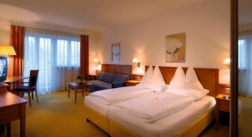 a hotel room with a large bed and a couch at Hotel Millanderhof in Bressanone