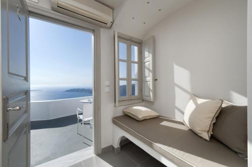 a room with a window and a bench with a view at Regina Mare-Adults Only Hotel in Imerovigli