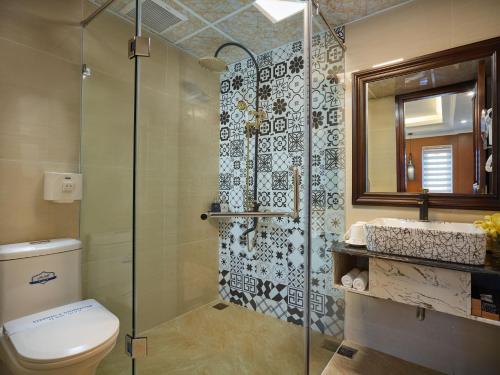 a bathroom with a shower and a toilet and a sink at Eden Boutique Hotel & Spa in Sa Pa