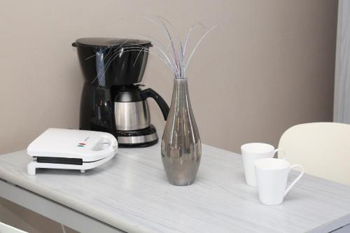 a glass vase sitting on a counter with a coffee maker at Blue Sky in Galissas
