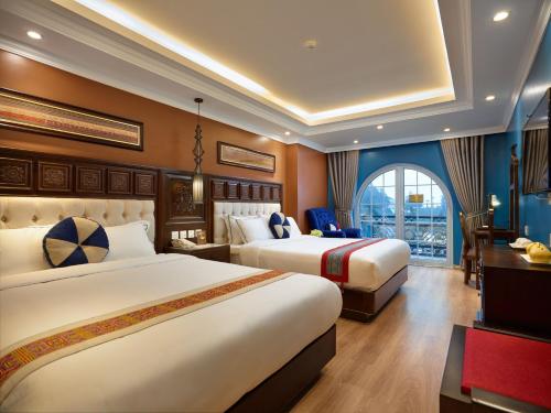 a hotel room with two beds and a window at Eden Boutique Hotel & Spa in Sapa