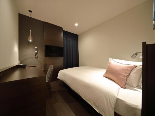 a hotel room with a bed and a desk at Red Roof Inn & Suites Osaka Namba Nipponbashi in Osaka