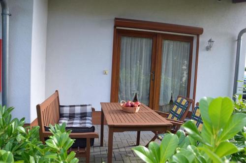 a table and chairs with a bowl of fruit on a patio at Ferienwohnanlage Jan in Neuendorf