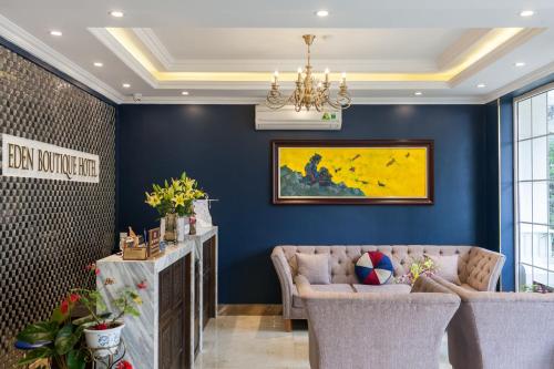 a living room with blue walls and a chandelier at Eden Boutique Hotel & Spa in Sa Pa