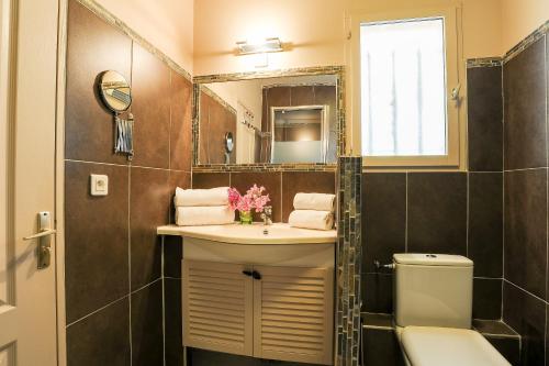 une salle de bain avec un lavabo, des toilettes et un miroir dans l'établissement Les Ilets de L'Eau Blanche, à Cavalaire-sur-Mer