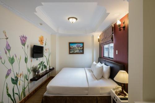 a hotel room with a bed and a tv at Asian Ruby Center Point Hotel & Spa in Ho Chi Minh City