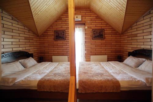 two twin beds in a room with a window at Hotel Harmony in Kutaisi