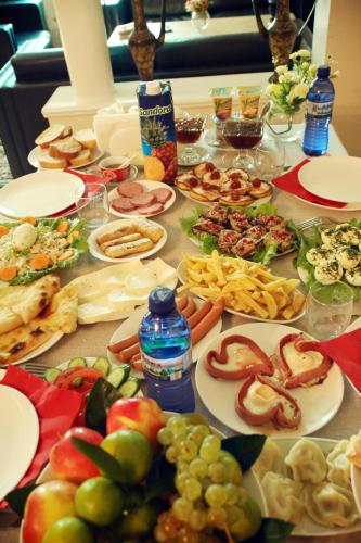 a table with many plates of food on it at Hotel Harmony in Kutaisi