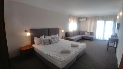 sypialnia z dużym łóżkiem i kanapą w obiekcie Family Hotel Muses w mieście Sozopol
