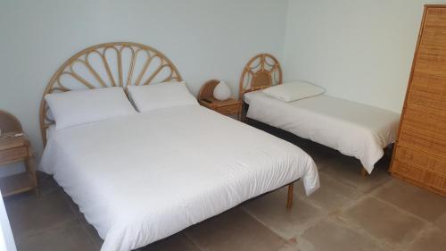 a bedroom with two beds with white sheets at Maison Tizi in Passoscuro
