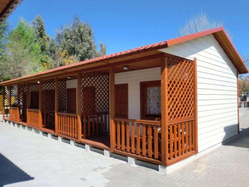 a small house with a porch with wooden railing at Camping Los Llanos in Denia