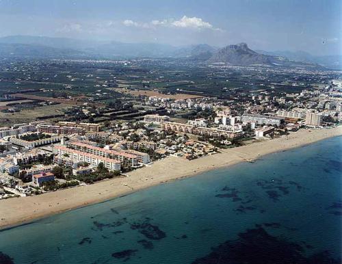 an aerial view of a beach with buildings and the ocean at Camping Los Llanos in Denia