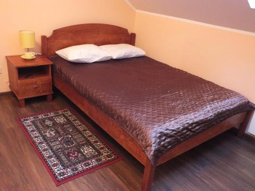 a bedroom with a wooden bed with a nightstand and a bed sidx sidx sidx at Tee Motell in Viitna