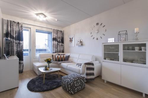 a living room with a couch and a clock on the wall at Vasko luxurious suites, Vasko in Rovaniemi