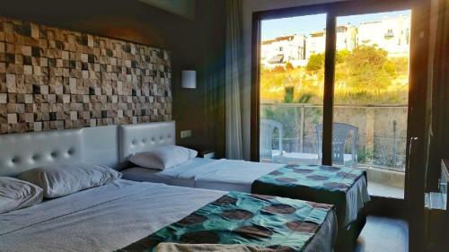a bedroom with two beds and a large window at Comfort Ada Class Hotel in Kuşadası